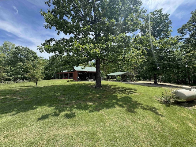 view of green lawn with a detached carport and a gazebo