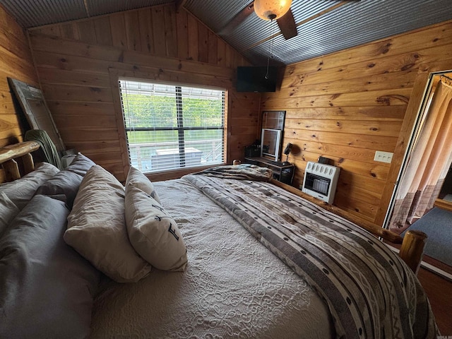 bedroom featuring heating unit, wood walls, and vaulted ceiling