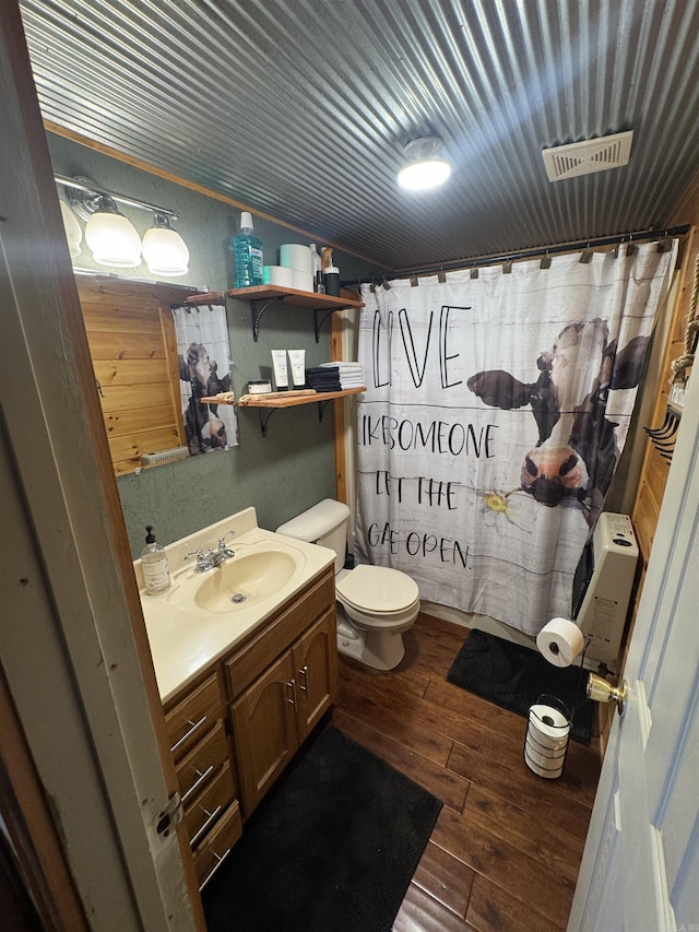 bathroom featuring vanity, toilet, wood-type flooring, and a shower with curtain