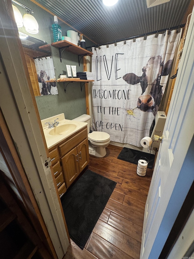 bathroom with hardwood / wood-style floors, vanity, toilet, and a shower with curtain