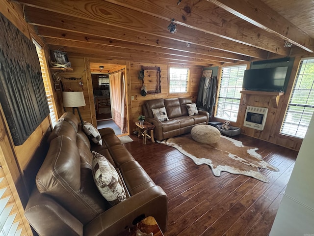 living area with heating unit, wood walls, wood-type flooring, beam ceiling, and a glass covered fireplace