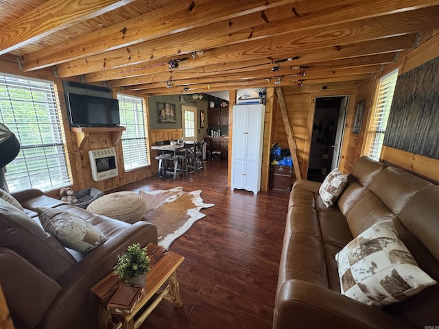 living room featuring wood walls, heating unit, dark wood finished floors, beam ceiling, and a large fireplace