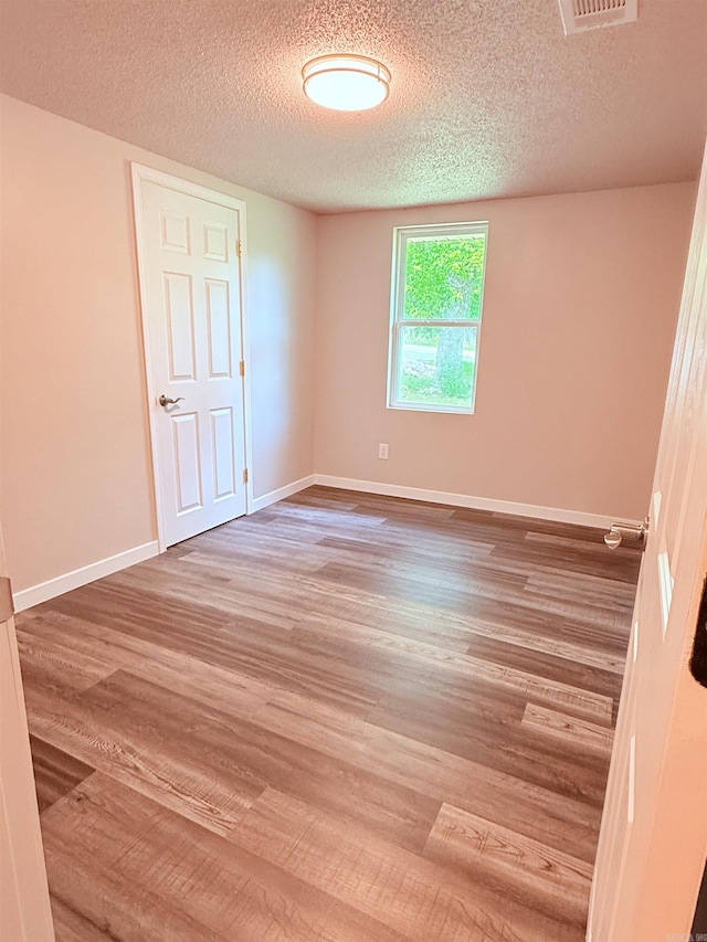 4090 Ar 56th Hwy, Wideman, AR 72585 - unfurnished bedroom featuring a textured ceiling, wood finished floors, and baseboards