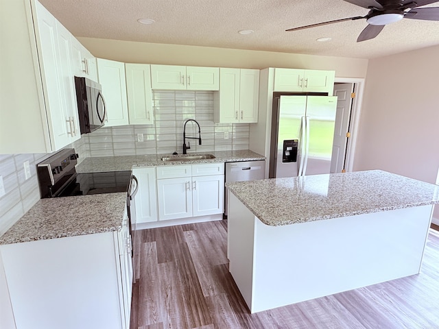 4090 Ar 56th Hwy, Wideman, AR 72585 - kitchen featuring stainless steel appliances, a sink, wood finished floors, a ceiling fan, and white cabinets