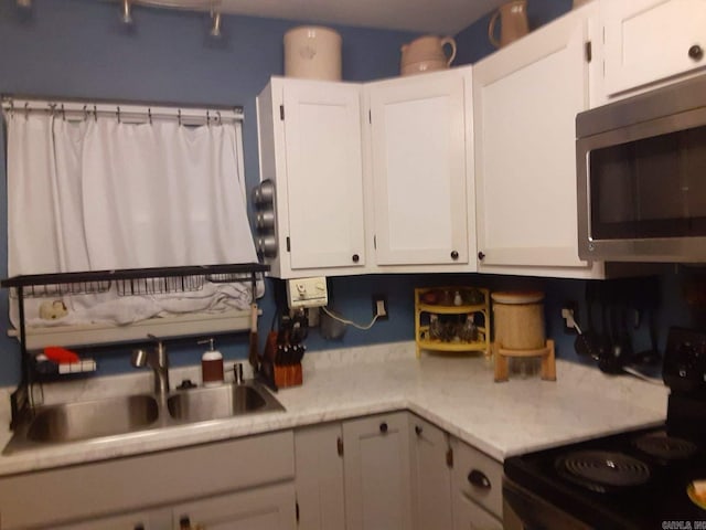 49 Tram, Perryville, AR 72126 - kitchen with stainless steel microwave, stove, light countertops, and white cabinets