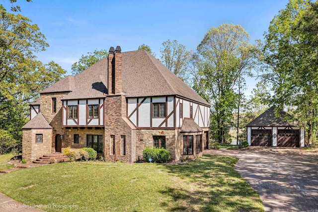 1920 Airpark Rd, Wynne, AR 72396 - tudor-style house featuring an outdoor structure, a detached garage, a shingled roof, a chimney, and a front yard
