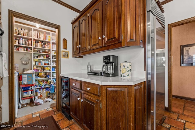 1920 Airpark Rd, Wynne, AR 72396 - bar featuring wine cooler, ornamental molding, stone finish floors, and stainless steel built in refrigerator