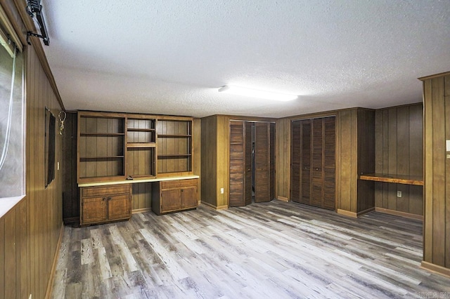 29 Flintwood Dr, Little Rock, AR 72227 - unfurnished office featuring a textured ceiling, built in study area, light wood-style floors, and wooden walls