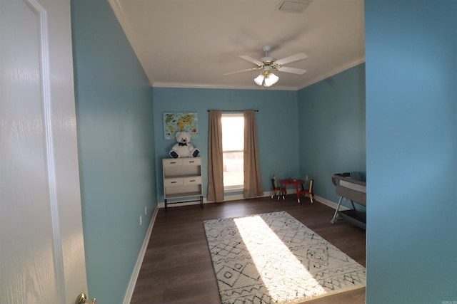 bedroom featuring ornamental molding, dark wood finished floors, baseboards, and a ceiling fan