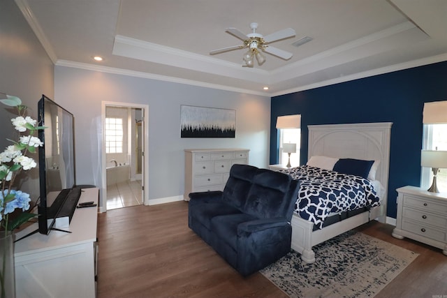 bedroom featuring a tray ceiling, wood finished floors, ornamental molding, baseboards, and recessed lighting