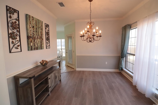 dining space with a chandelier, ornamental molding, healthy amount of natural light, dark wood-style flooring, and baseboards