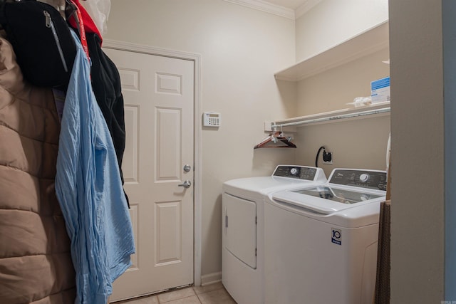 laundry room with crown molding, independent washer and dryer, and light tile patterned floors