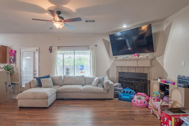 living room featuring ceiling fan, wood finished floors, ornamental molding, a fireplace, and recessed lighting