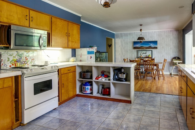 312 N E St, Harrisburg, AR 72432 - kitchen featuring stainless steel microwave, white electric range, tile countertops, open shelves, and a peninsula