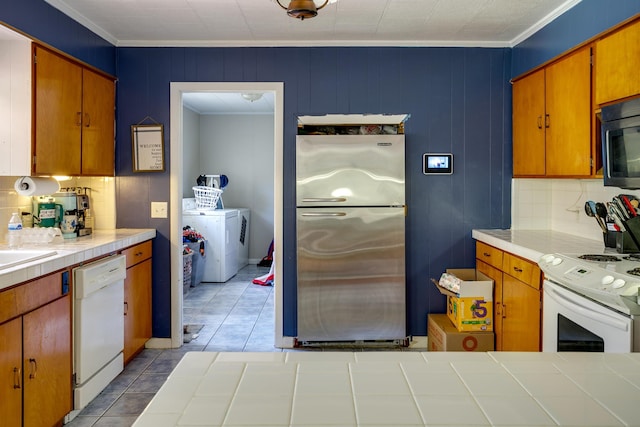 312 N E St, Harrisburg, AR 72432 - kitchen with white appliances, tile countertops, decorative backsplash, tile patterned floors, and crown molding