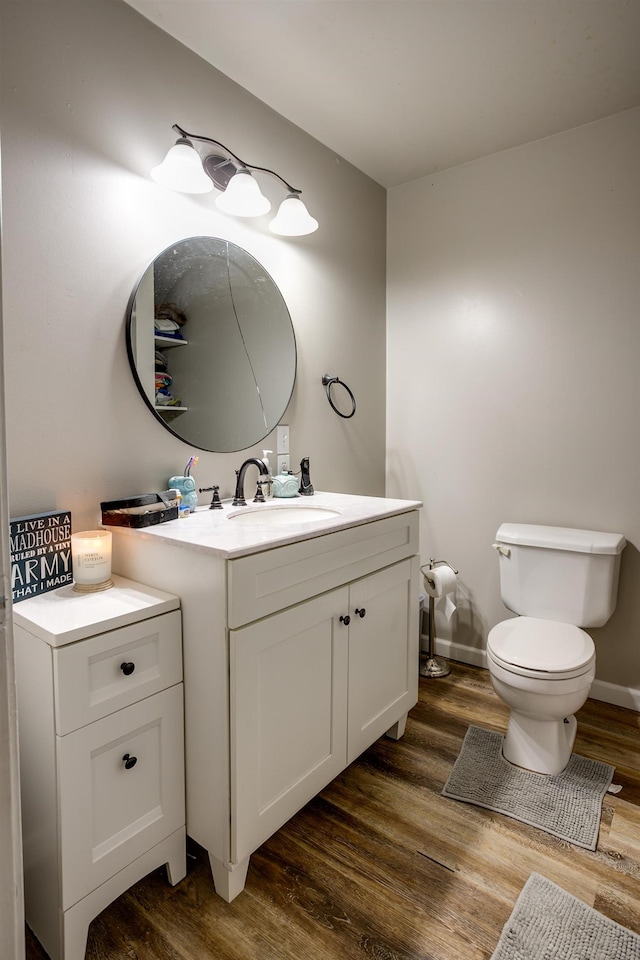 312 N E St, Harrisburg, AR 72432 - half bath with wood finished floors, toilet, vanity, and baseboards