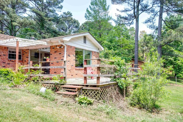312 N E St, Harrisburg, AR 72432 - view of side of property with brick siding and a deck