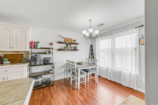 142 Peach St, Austin, AR 72007 - dining space with a chandelier, ornamental molding, wood finished floors, and baseboards