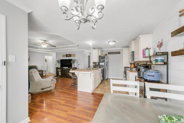 142 Peach St, Austin, AR 72007 - kitchen with appliances with stainless steel finishes, open floor plan, a kitchen bar, light countertops, and white cabinetry