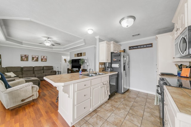 142 Peach St, Austin, AR 72007 - kitchen with stainless steel appliances, a sink, a peninsula, white cabinets, and ceiling fan