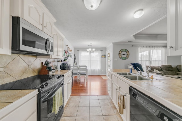 142 Peach St, Austin, AR 72007 - kitchen featuring black appliances, tile counters, a sink, plenty of natural light, and crown molding