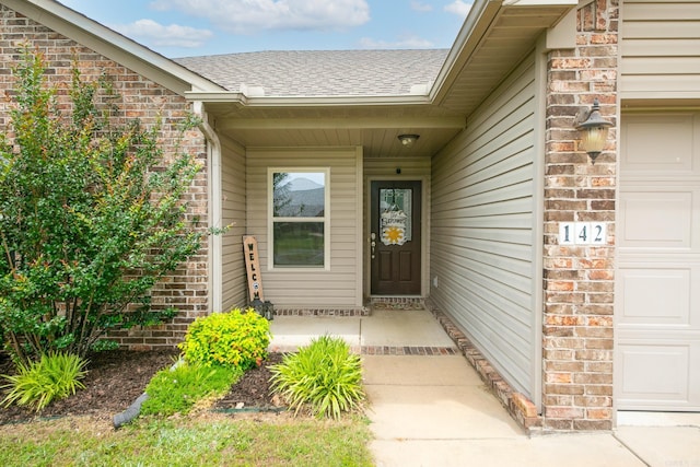 142 Peach St, Austin, AR 72007 - doorway to property featuring brick siding, a garage, a shingled roof, and a porch