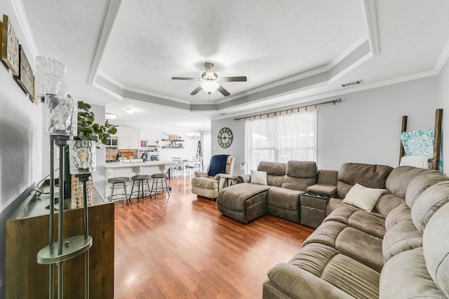 142 Peach St, Austin, AR 72007 - living room with a tray ceiling, ceiling fan, wood finished floors, and ornamental molding