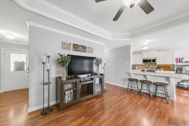 142 Peach St, Austin, AR 72007 - living area featuring dark wood-style flooring, crown molding, ceiling fan, baseboards, and a raised ceiling