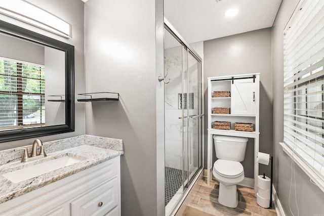 4 Desoto Forest Cv, Little Rock, AR 72211 - bathroom with a stall shower, toilet, wood finished floors, vanity, and baseboards