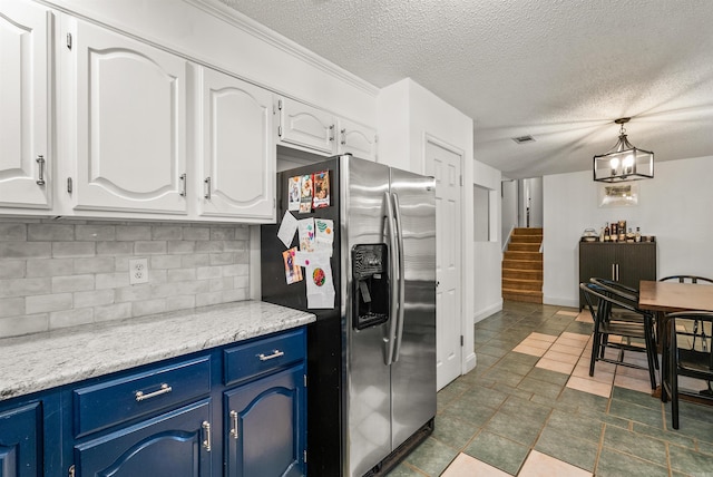 4 Desoto Forest Cv, Little Rock, AR 72211 - kitchen with stainless steel refrigerator with ice dispenser, blue cabinetry, white cabinetry, backsplash, and pendant lighting