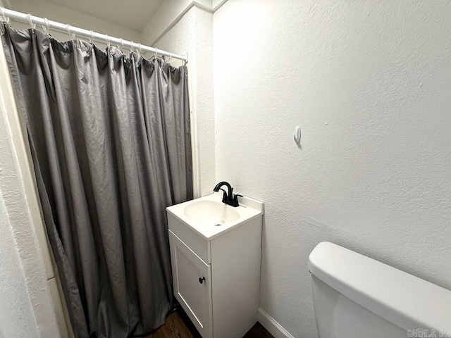 601 Clarence St, Mountain View, AR 72560 - bathroom with toilet, vanity, a textured wall, and curtained shower