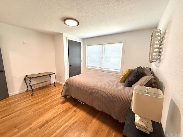601 Clarence St, Mountain View, AR 72560 - bedroom with light wood-type flooring, a textured ceiling, and baseboards