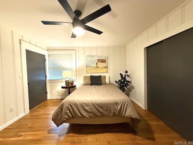 601 Clarence St, Mountain View, AR 72560 - bedroom featuring wood finished floors, baseboards, ceiling fan, and a decorative wall