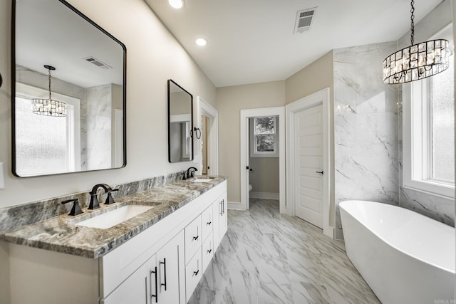 912 Lakeshore Dr, Heber Springs, AR 72543 - bathroom featuring a chandelier, marble look tiles, healthy amount of natural light, recessed lighting, and a freestanding bath