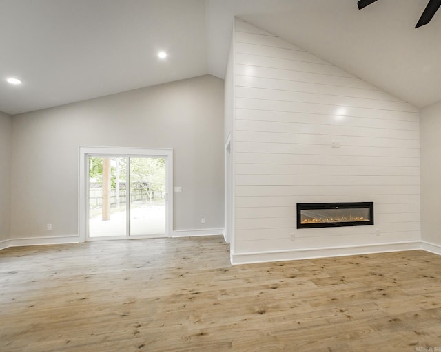 912 Lakeshore Dr, Heber Springs, AR 72543 - unfurnished living room featuring high vaulted ceiling, a large fireplace, wood finished floors, baseboards, and ceiling fan