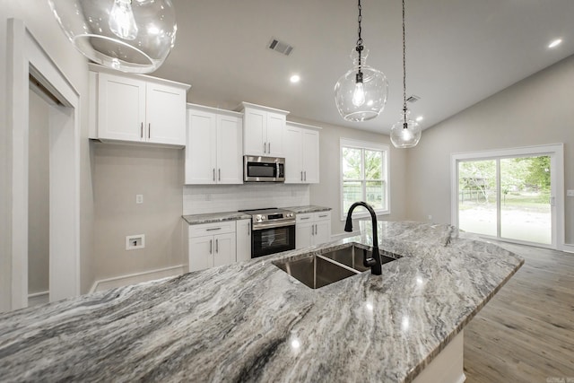 912 Lakeshore Dr, Heber Springs, AR 72543 - kitchen featuring stainless steel appliances, a sink, lofted ceiling, decorative backsplash, and white cabinetry