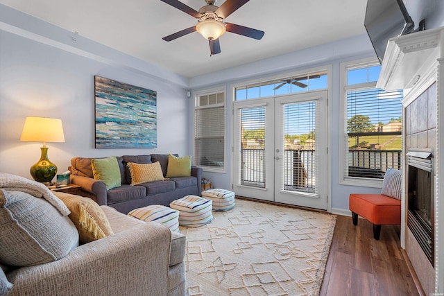 living area featuring french doors, ceiling fan, wood finished floors, and baseboards