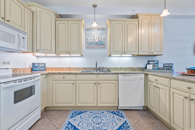 kitchen featuring white appliances, a sink, cream cabinets, hanging light fixtures, and light stone countertops