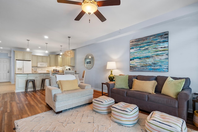 living room with light wood-style floors, a ceiling fan, recessed lighting, and baseboards