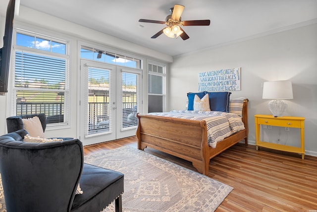 bedroom featuring french doors, access to outside, light wood-style floors, crown molding, and a ceiling fan