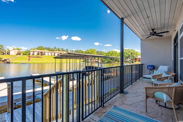 balcony with a water view and a ceiling fan