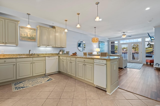 kitchen featuring dishwasher, a sink, cream cabinets, a peninsula, and ceiling fan