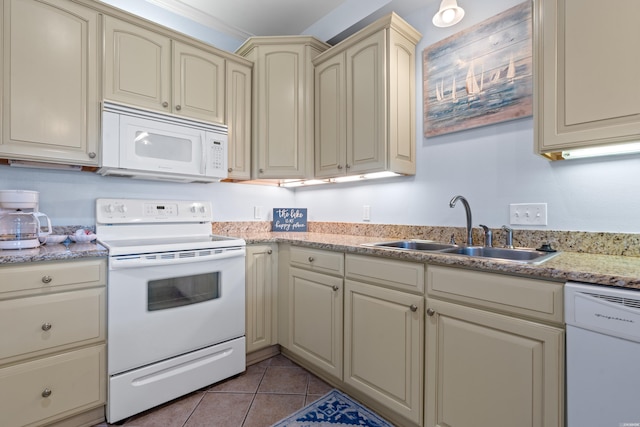 kitchen with white appliances, a sink, cream cabinets, and light tile patterned floors