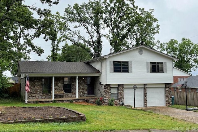split level home with stone siding, dirt driveway, an attached garage, and covered porch