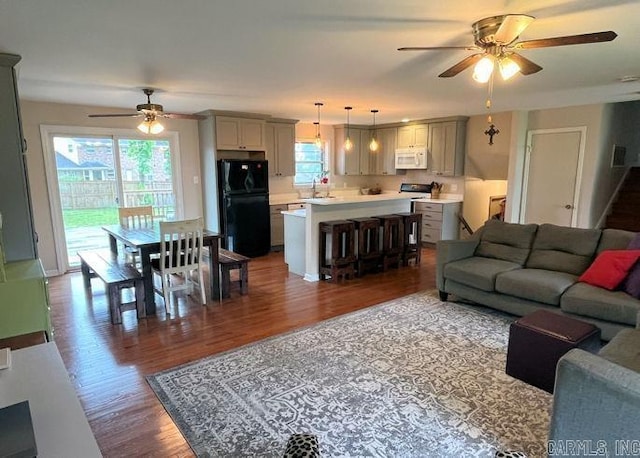 living room featuring ceiling fan, plenty of natural light, and wood finished floors