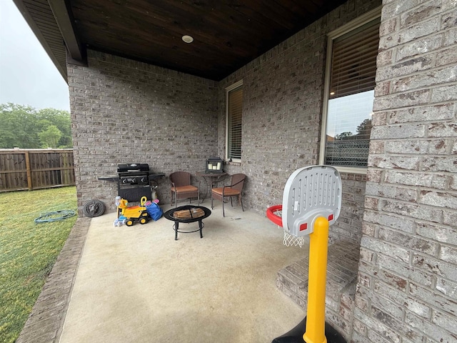 view of patio with an outdoor fire pit, fence, and grilling area