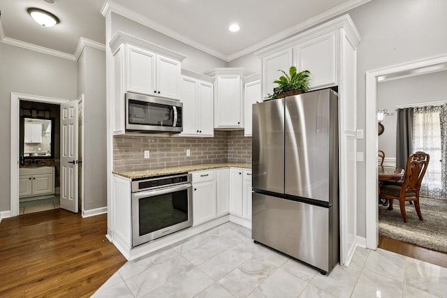 2724 Crooked Stick Dr, Benton, AR 72015 - kitchen with stainless steel appliances, light stone countertops, white cabinets, ornamental molding, and tasteful backsplash