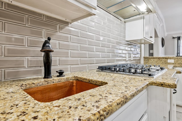 2724 Crooked Stick Dr, Benton, AR 72015 - kitchen with exhaust hood, decorative backsplash, stainless steel gas stovetop, light stone countertops, and a sink