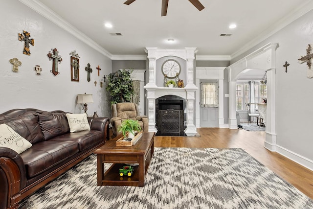 2724 Crooked Stick Dr, Benton, AR 72015 - living area with ceiling fan, a fireplace, arched walkways, wood finished floors, and crown molding