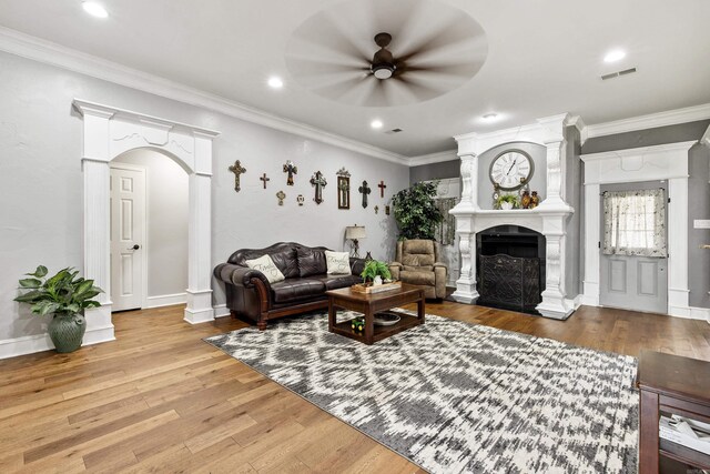 2724 Crooked Stick Dr, Benton, AR 72015 - living area with a ceiling fan, wood finished floors, a fireplace with raised hearth, arched walkways, and crown molding
